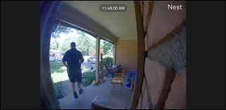A doorbell camera showing a man walking away from a door.