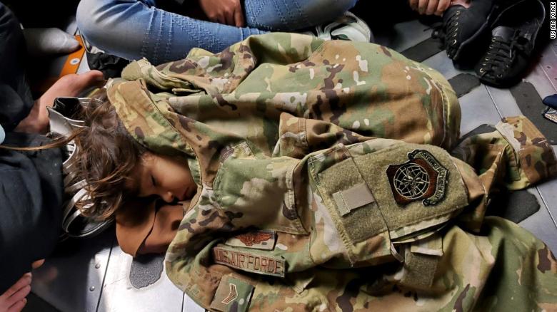 An Afghan child sleeps on the cargo floor of a U.S. Air Force C-17 Globemaster III on Sunday, in a photo released by the US Air Force. Afghans have struggled to get through desperate crowds outside Kabul's airport this week.