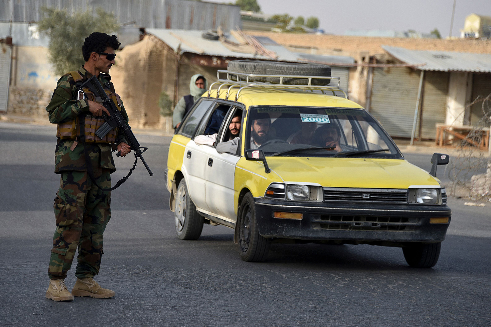 An Afghan security personnel stands guard along a road in Kandahar on July 14.