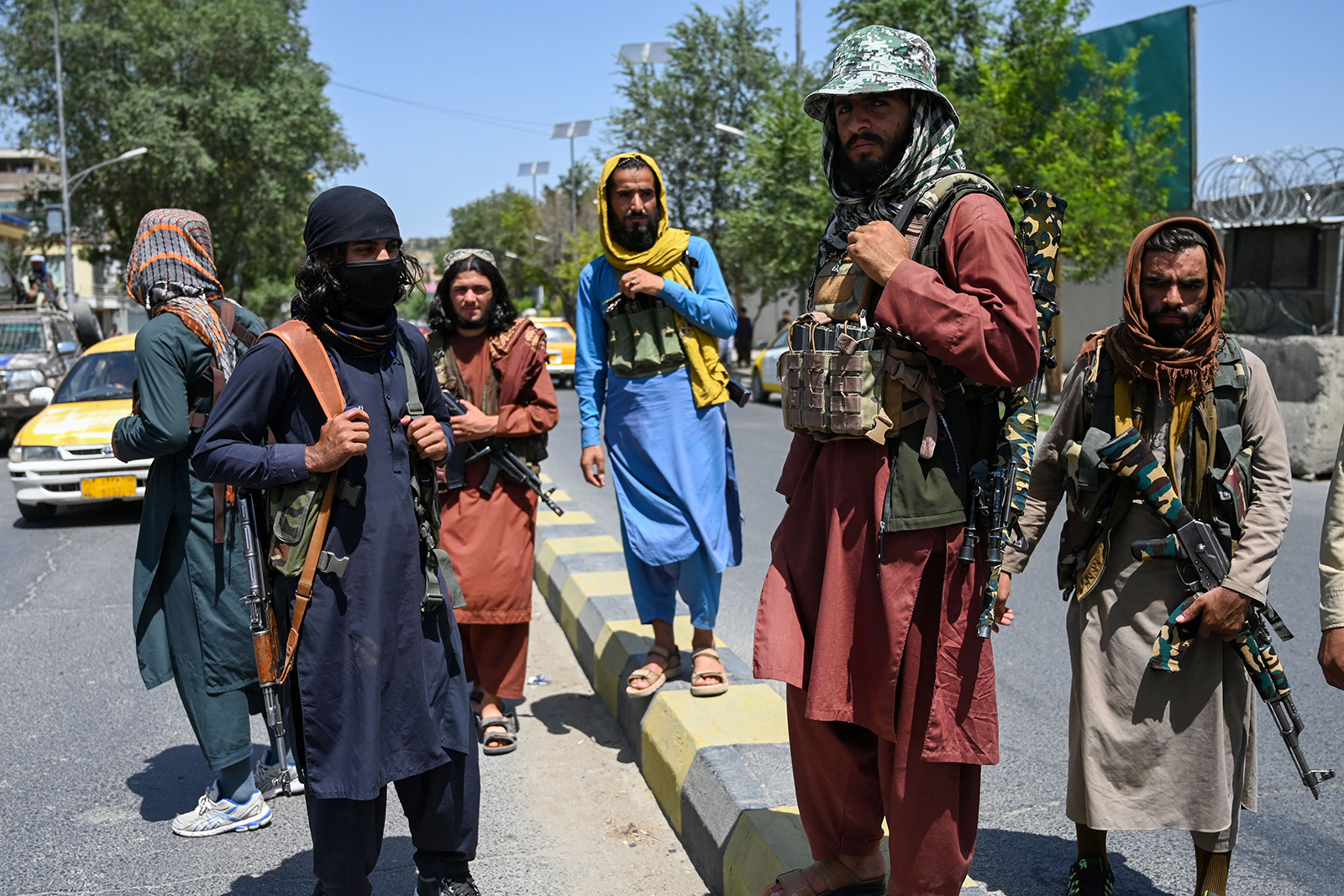 Taliban fighters stand guard along a street near the Zanbaq Square in Kabul on August 16.