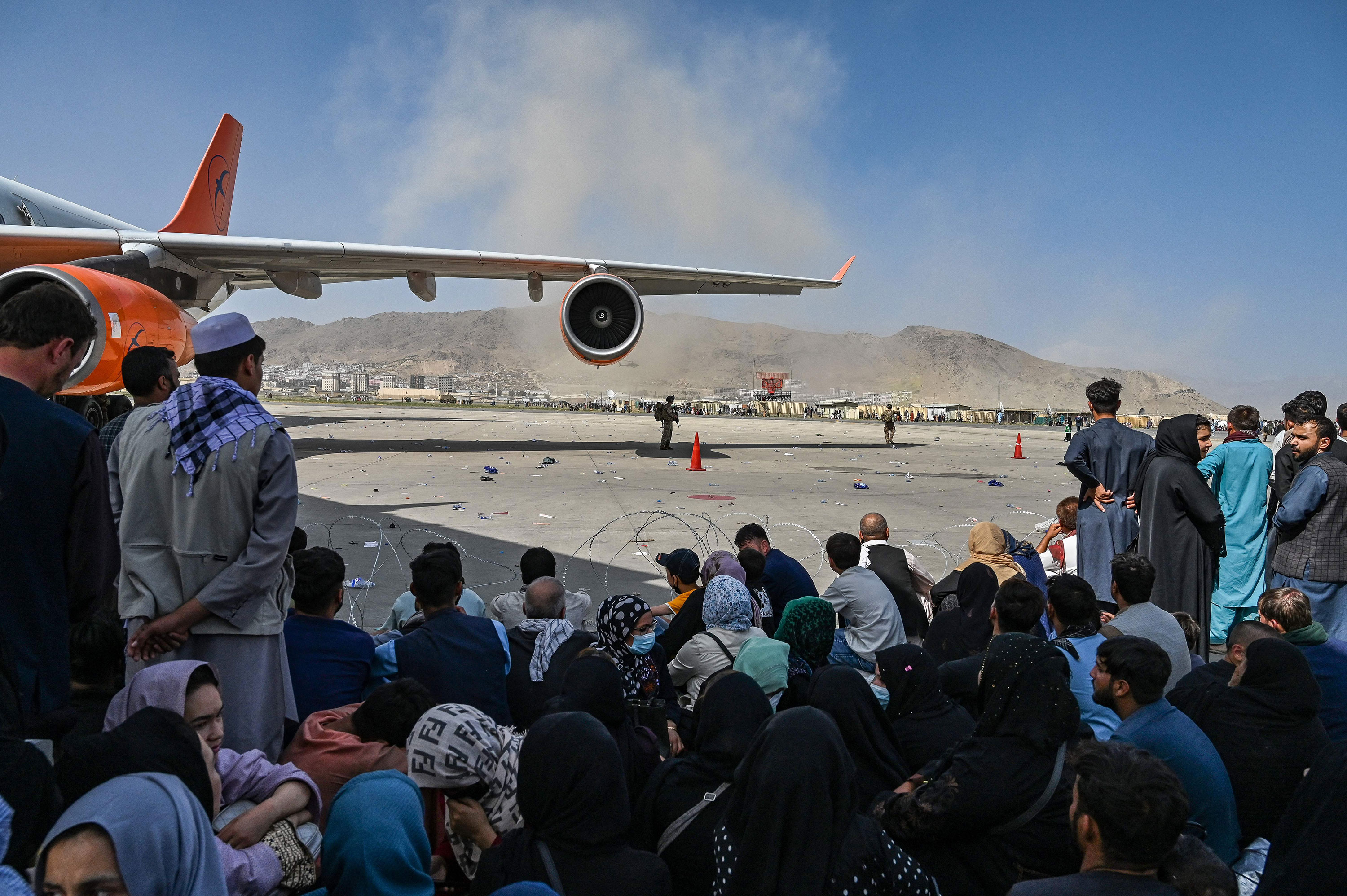 People wait to leave the airport in Kabul on August 16.