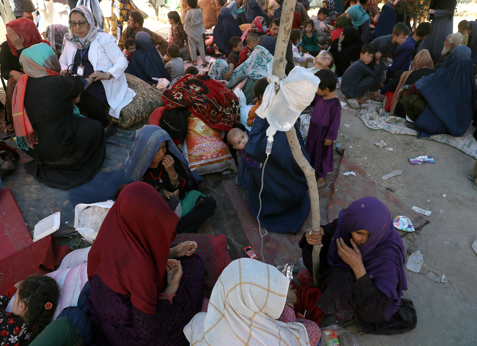 Internally displaced Afghan women from northern provinces, who fled their home due to fighting between the Taliban and Afghan security personnel, receive medical care in a public park in Kabul on August 10.