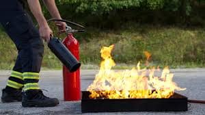 A man demonstrating how to safely operate a fire extinguisher