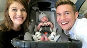 A father and mother excited about their little baby in an infant car seat